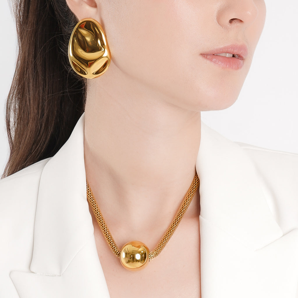 A woman with a sleek, wet-hair look gazes into the camera, exuding effortless elegance.