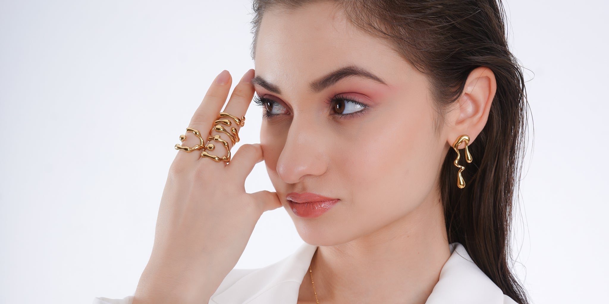Woman wearing 18K gold-plated statement ring and molten drop earrings — demi-fine jewellery styled with modern elegance.