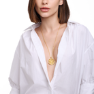 Embrell Becoming Aura Pendant Necklace in 22K gold-plated finish, handcrafted molten textured round pendant on a fine chain, demi-fine jewellery styled with a white shirt for a modern elegant look.