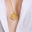 Embrell Becoming Aura Pendant Necklace in 22K gold-plated finish, handcrafted molten textured round pendant on a fine chain, demi-fine jewellery styled with a white shirt for a modern elegant look.