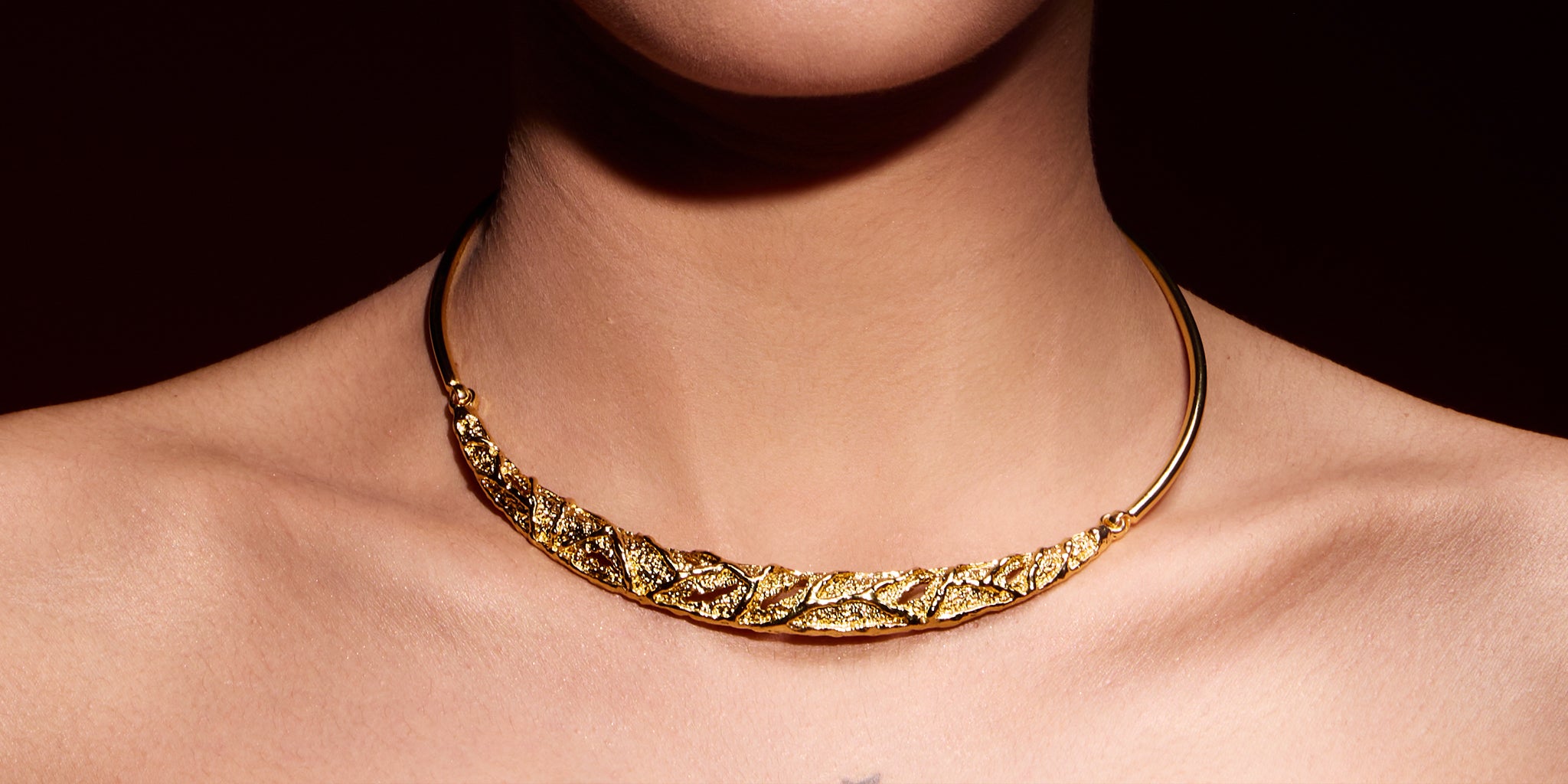 18K Gold plated necklace on a person against a dark background