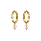 Pair of gold beaded earrings with pearl drops on a white background