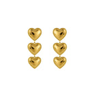 Gold heart-shaped earrings on a white background
