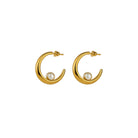 Gold hoop earrings with pearl centers on a white background