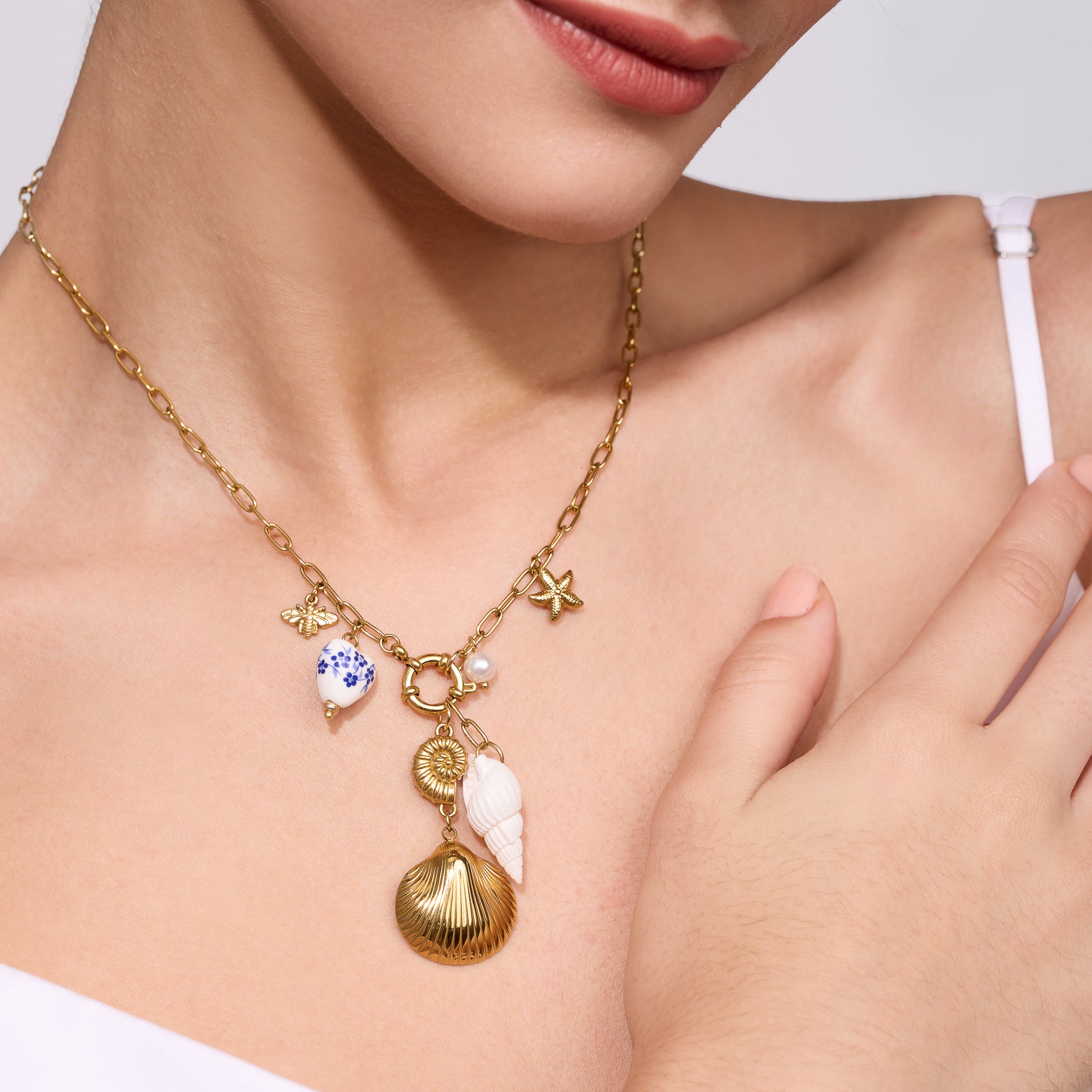 Gold necklace with charms worn by a women