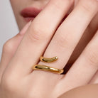 Gold ring on a finger with a plain background