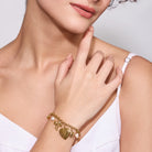 18K gold plated bracelet with heart charm worn by a person against a neutral background