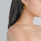 Model wearing 18K gold-plated triangular stud earrings, showcasing their bold, geometric design and polished finish.