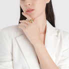 Model wearing an 18K gold-plated open ring with a flowing cutout design, adding a modern, polished touch to her minimal outfit.