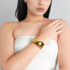 Model wearing an 18K gold-plated wide bracelet with a sleek, polished finish, adding a bold touch of elegance to her minimalist look