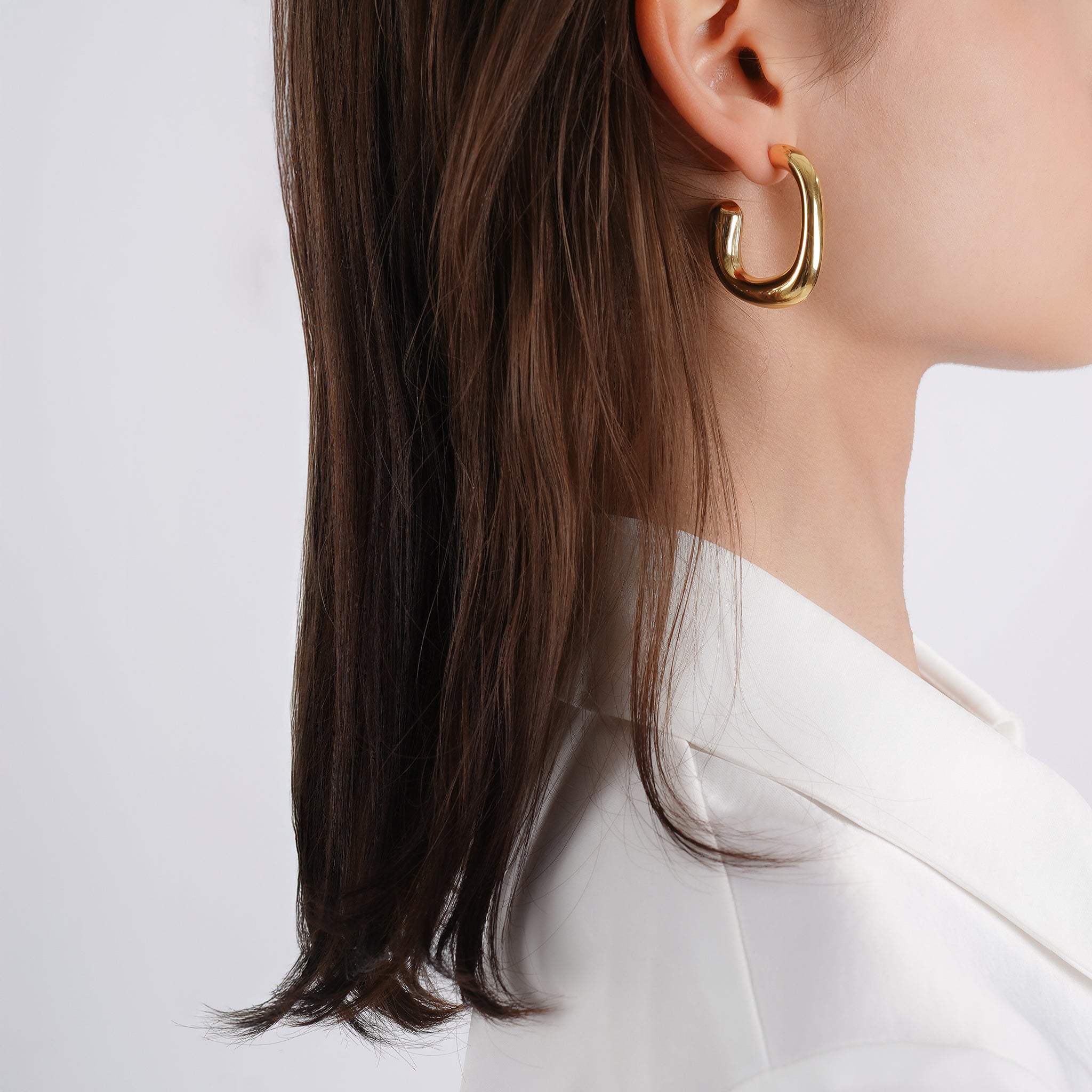 18K gold-plated bold curved hoop earrings, perfectly crafted to frame the face with a touch of elegance and modern design.
