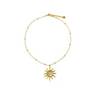 Gold necklace with a sun-shaped pendant on a white background