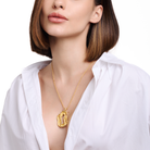 Embrell Becoming Lumen Pendant Necklace in 22K gold-plated finish, handcrafted molten textured open pendant on a fine chain, demi-fine jewellery styled with a white shirt for an elegant bold look.