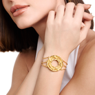 Embrell Becoming Origin Bracelet in 22K gold-plated finish, handcrafted molten textured circular motif with triple chain design, demi-fine jewellery worn by a woman for a bold elegant look.