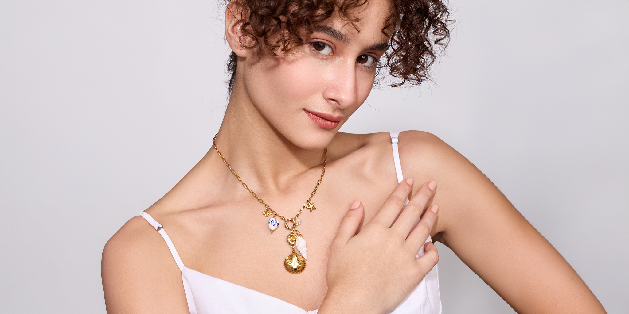 Woman wearing a gold necklace with a white background