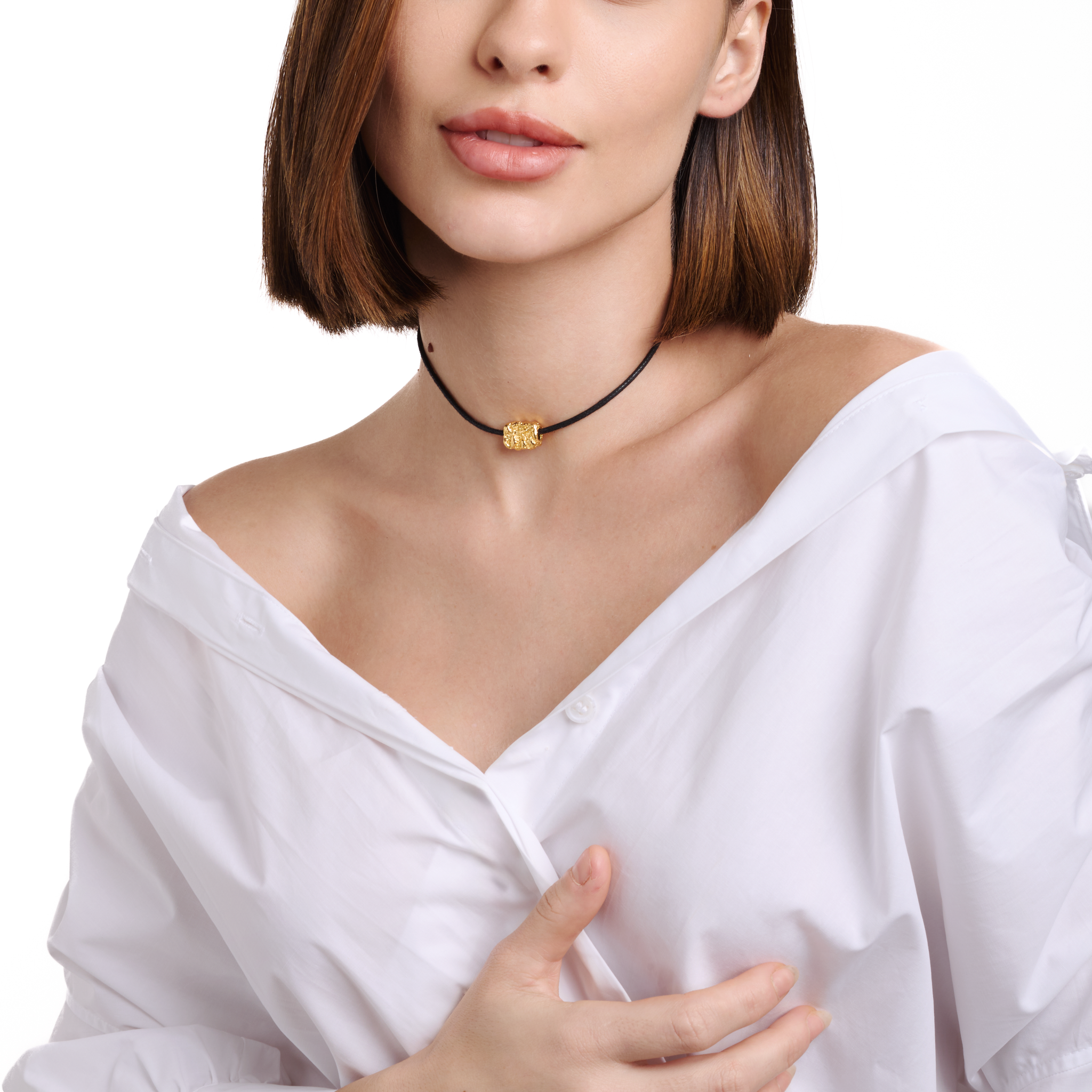 Embrell Becoming Talisman Necklace in 22K gold-plated finish, handcrafted molten textured pendant on a black choker cord, demi-fine jewellery worn by a woman styled with a white shirt for a bold modern look.