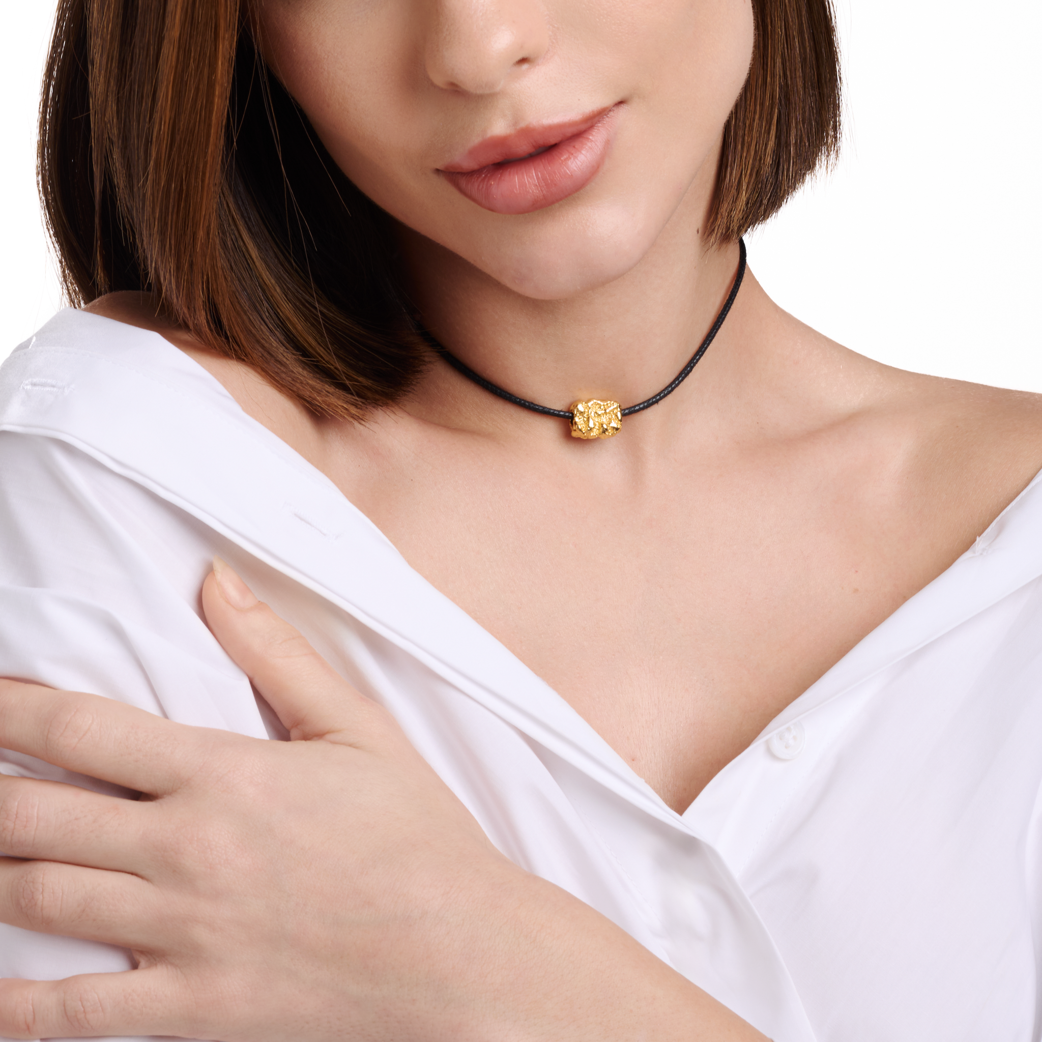 Embrell Becoming Talisman Necklace in 22K gold-plated finish, handcrafted molten textured pendant on a black choker cord, demi-fine jewellery worn by a woman styled with a white shirt for a bold modern look.